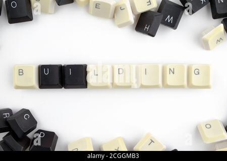 Computer und Computertechnologien in den Industrien und den Bereichen der menschlichen Tätigkeit - Konzept. Gebäude. Auf einem weißen Hintergrund von den verstreuten Schlüsseln Stockfoto