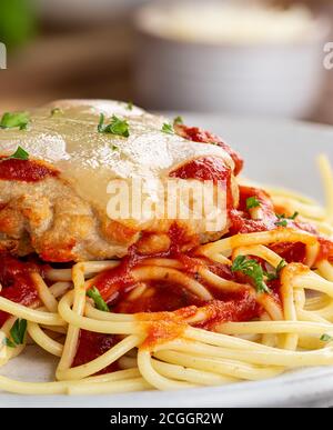 Nahaufnahme von Chicken Parmesan Mahlzeit mit Spaghetti Pasta und Tomaten Sauce auf einem Teller Stockfoto