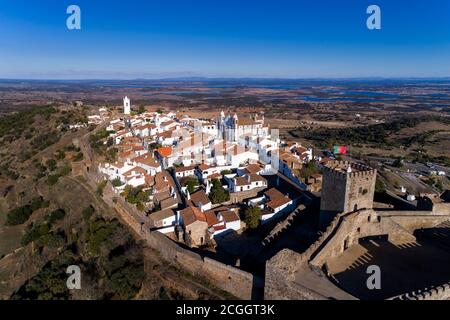 Luftaufnahme des schönen Dorfes Monsaraz, mit dem Alqueva Damm im Hintergrund, in Alentejo, Portugal. Stockfoto