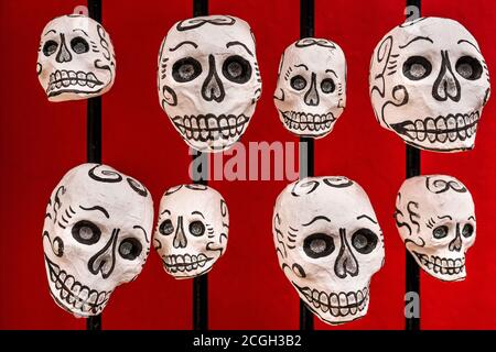 Bei den Feierlichkeiten zum Tag der Toten in Oaxaca, Mexiko, sind handbemalte Schädel (Calaveras) an einer Straßentür zu sehen. Stockfoto