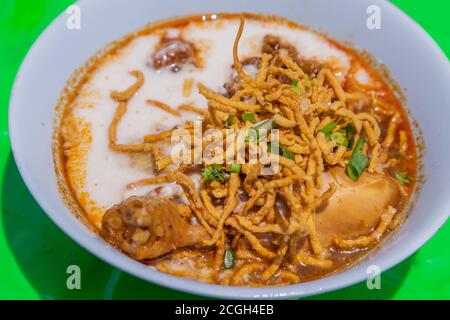Traditionelles Khao Soi Rezept, Thai Northern Style Curried Nudelsuppe mit Huhn in weißer Schüssel. Selektiver Fokus. Stockfoto