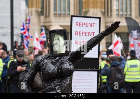 Eine männliche faschistische Demonstranten, die gegen eine erste Kundgebung der neu gegründeten britischen Zweigstelle von Pegida (patriotische Europäer gegen die Islamisierung des Westens) demonstrierten, gekleidet als eine Frau, die ein ipad trägt und einen Film über Hitler zeigt. Die Pegida-Kundgebung war, um gegen das zu protestieren, was sie sagen, ist Islamisierung Großbritanniens. Weniger als 100 Menschen kamen heraus, um die Pegida-Kundgebung zu unterstützen.Sie wurden von einer Anti-Pegida-Protestierenden stark herausgezählt. Pegida startete im Oktober 2014 in Dresden Deutschland, patriotische Europäer gegen die Islamisierung des Abendlandes Stockfoto