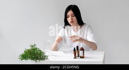 Der Wissenschaftler, Dermatologe testet das organische Naturkosmetikprodukt im Labor. Fläschchen, Laborflaschen aus Glas. Beauty kosmetische Forschung und Entwicklung Konzept. Stockfoto