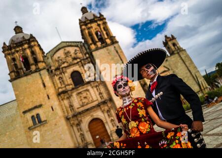 Eine junge Mexikanerin, bekleidet als La Catrina, begleitet von einem jungen Mexikaner, nimmt am Tag der Toten Festival in Oaxaca, Mexiko, Teil. Stockfoto