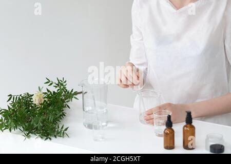 Der Wissenschaftler, Dermatologe testet das organische Naturkosmetikprodukt im Labor. Fläschchen, Laborflaschen aus Glas. Beauty kosmetische Forschung und Entwicklung Konzept. Stockfoto