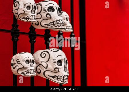 Bei den Feierlichkeiten zum Tag der Toten in Oaxaca, Mexiko, sind handbemalte Schädel (Calaveras) an einer Straßentür zu sehen. Stockfoto