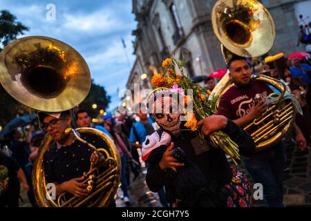 Eine Mexikanerin, die eine Totenkopfmaske trägt, tritt auf der Straße während des Day of the Dead Festivals in Oaxaca, Mexiko, auf. Stockfoto