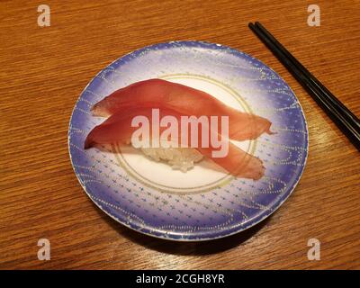 Thunfisch-Sushi auf kleinem Teller. Beliebtes Sushi-Restaurant mit Förderband in Seoul. Stockfoto