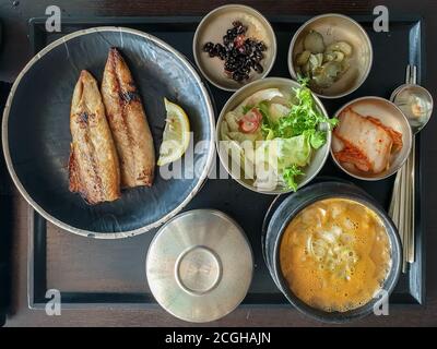 Seoul, Korea – Godeungeo-gui, Makrele im koreanischen Stil mit gesalzenem Grill. Cheonggukjang jjigae in Steintopf, Eintopf aus fermentierter Sojabohnenpaste. Stockfoto