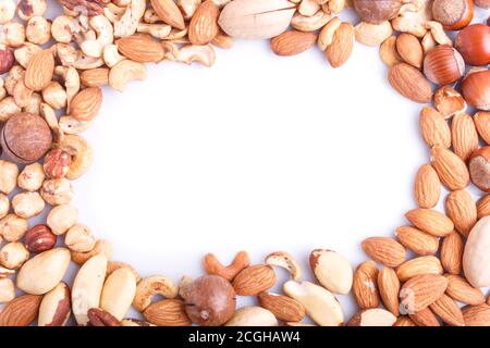 Rahmen aus verschiedenen Arten von Nüssen auf weißem Hintergrund. Haselnuss, paranuss, Mandel, Kürbiskerne, Cashew. Draufsicht. Stockfoto