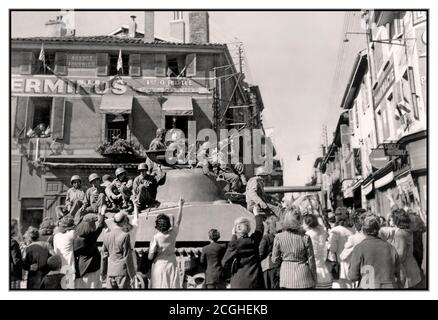 WW2 France Befreiung in einer französischen Provinzstadt, nach dem D-Day mit der schnell voranschreitenden amerikanischen 45. Infanterie-Division. Lokale Dorfbewohner winken und drängen sich glücklich um ihre US-Armeebefreier, die auf ihrem amerikanischen Panzer sitzen und den enthusiastischen Herzlich Willkommen. genießen September 1944. Zweiter Weltkrieg Zweiter Weltkrieg Stockfoto