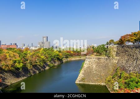 Wunderschöne Stadtlandschaft im Herbst, bunte Wälder und Graben und alte Stadtmauer, der Osaka Castle Park, Osaka, Japan Stockfoto