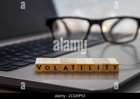 VOLATILITY Letter blockiert Business Finance Konzept auf Laptop-Tastatur mit Haus und Rechner Stockfoto