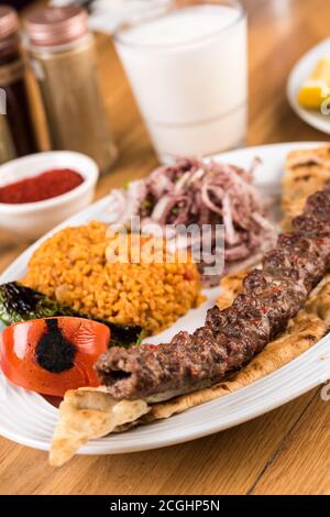 Türkischer Adana Kebab mit Gemüse auf Holztisch Stockfoto