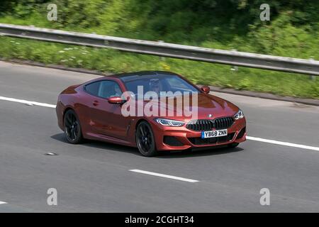 2018 orange BMW 840D xDrive Auto; Fahren auf der Autobahn M6 bei Preston in Lancashire, Großbritannien Stockfoto