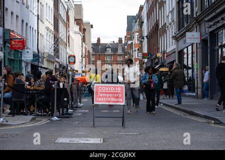 Die Restaurants nehmen ihre Tische nach dem Lockdown in Soho London nach draußen Einschränkungen gelockert COVID 19 Stockfoto