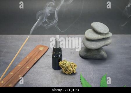 Glasflasche mit CBD-Öl und Hanfblättern auf schwarzem Holzhintergrund. Organische und natürliche Kosmetik- und Kosmetikprodukte auf Hanfbasis. Medizinisches Cannabis. Stockfoto