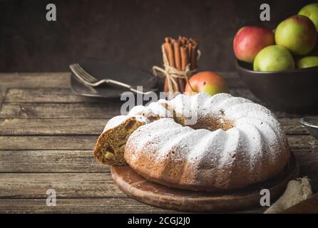 Landhausstil Apple Bundt Cake bestreut mit Puderzucker auf alten Holztisch Stockfoto