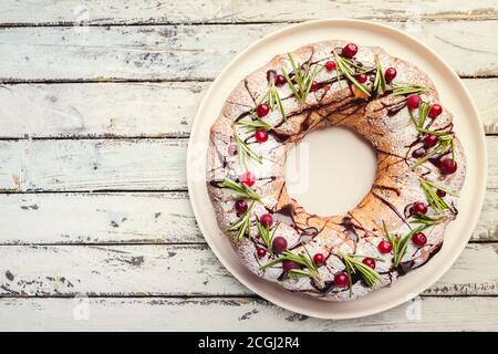 Preiselbeeren bundt Cake mit Schokolade und Orange auf einem weißen Teller. Hausgemachte Herbst und Winter gemütliches Dessert auf rustikalen Holztisch, Ansicht von oben Stockfoto