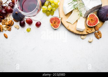 Camembert oder Brie Käse mit frischen Feigen, Honigwabe, Glas Wein auf das Brett über weißen Hintergrund, Ansicht von oben, kopieren Raum Stockfoto