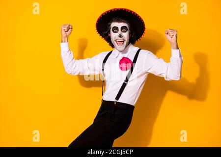 Foto-Porträt von fröhlich verrückt schön hübsch lustig mexikanischen Kerl In der traditionellen Tracht heben Fäuste bis isoliert helle Farbe gelb Hintergrund Stockfoto
