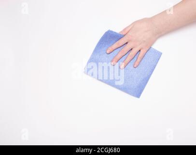 Teil der Hand mit einem blauen Tuch zum Abstauben und Entfernen von Schmutz. Reinigung, weißer Hintergrund, freier Platz für Text. Stockfoto