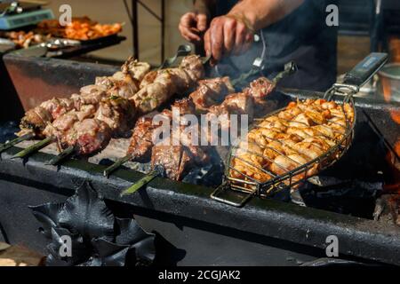 Gegrillter Kebab auf Metallspieß. Gebratenes Fleisch gekocht am Grill.traditionelle östliche Gericht, Shish Kebab. Grill auf Holzkohle und Flamme, Picknick Stockfoto