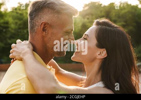 Portrait von glücklichen Paare im mittleren Alter Mann und eine Frau sich einander und Umarmen beim Gehen im Sommer Park Stockfoto