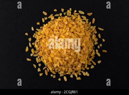 Bulgur Weizenkörner isoliert auf schwarzem Hintergrund Stockfoto