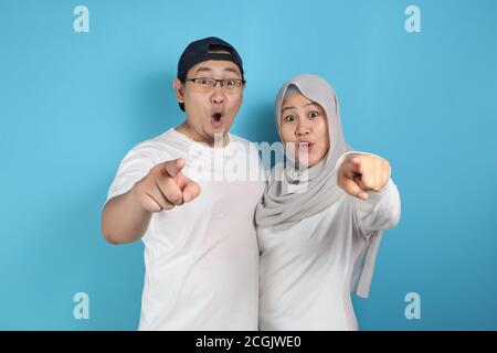 Portait von glücklich asiatischen muslimischen Paar lächelnd und zeigt auf Kamera, Mann und Frau umarmt voller Liebe, Familienkonzept Stockfoto