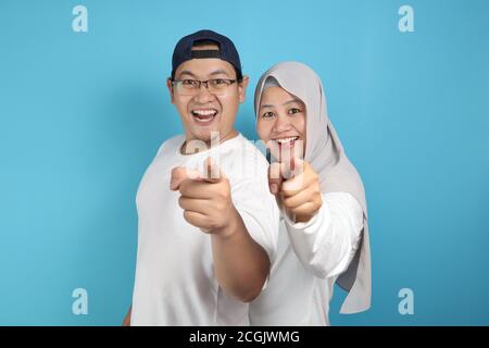 Portait von glücklich asiatischen muslimischen Paar lächelnd und zeigt auf Kamera, Mann und Frau umarmt voller Liebe, Familienkonzept Stockfoto