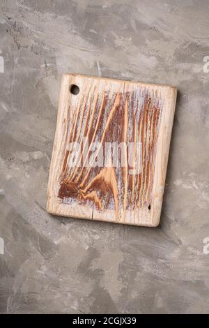 Handgefertigtes altes Holz Schneidebrett auf Steinbeton Hintergrund, Draufsicht Stockfoto