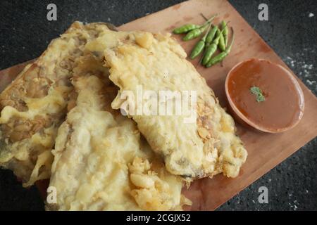 Gorengan tempe, indonesischer gebratener tempe-Snack, serviert mit Sambal- oder Chilisauce und Chilischote, serviert auf Holzplatte Stockfoto