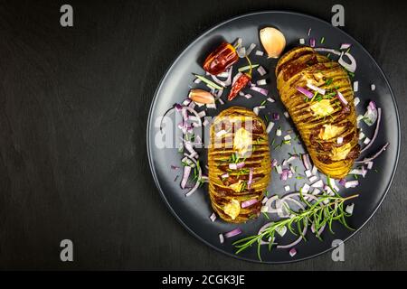 Frisch gebackene hasselback Kartoffeln mit Schnittlauch. Appetitliche Kartoffel-Akkordeon im Ofen gebacken. Stockfoto