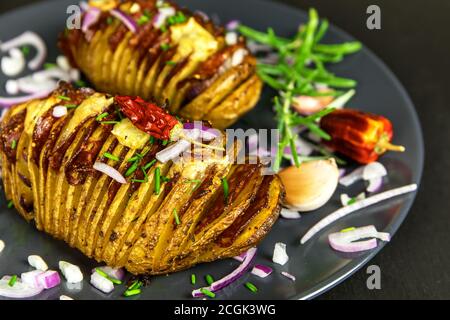 Frisch gebackene hasselback Kartoffeln mit Schnittlauch. Appetitliche Kartoffel-Akkordeon im Ofen gebacken. Stockfoto