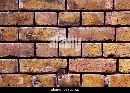 Viktorianische gelbe Mauerwerk Wand strukturierten Hintergrund mit Mörtel erodiert weg Zwischen Ziegeln Stockfoto