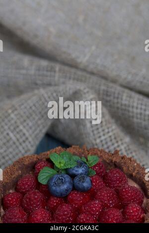 No-Bake Schokoladenkuchen mit Frischkäse. Garniert mit Himbeeren, Heidelbeeren und Minzblättern. Stockfoto