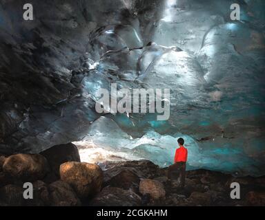 Mann, Teenager steht in der Eishöhle Alibek Gletscher in Dombay Stockfoto