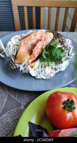 Draufsicht auf foliengebackene Lachssteaks und frisches Gemüse, selektiver Fokus Stockfoto