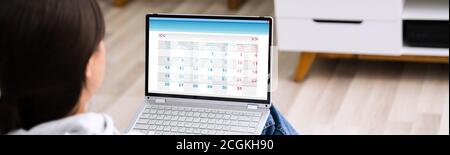 Frau Suchen In Kalender Auf Laptop-Computer Stockfoto