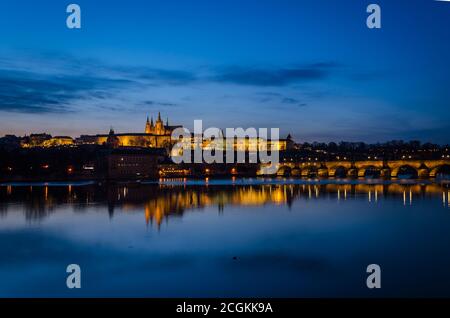 Nachtansicht von Prag bei blauer Stunde mit den Lichtern auf dem Moldava-Fluss reflektiert, Prag, Tschechische Republik Stockfoto