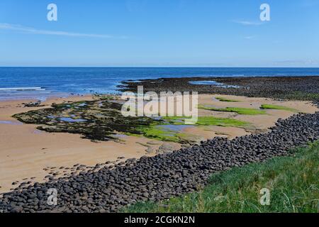 Sonnenuntergang über Embleton Beach in der Nähe von Dunstanburgh Castle in Northumberland Stockfoto