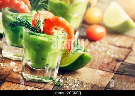 Festlicher Snack, Garnelen und Avocado-Sauce in Schnapsglas, alter Holzhintergrund, selektiver Fokus Stockfoto