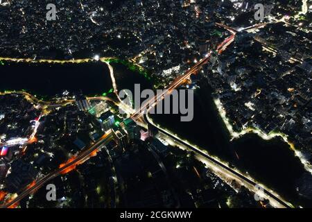 Dhaka, Bangladesch. September 2020. Luftaufnahme von Drone: Nachtstadt, die über die Straße fliegt und Nachtlichter, in Dhaka, Bangladesch, 11. September 2020. Mit einer Dichte von 47,400 Menschen pro Quadratkilometer blieb Dhaka die am dichtesten besiedelte Stadt der Erde. Die Bevölkerung von Dhaka steigt jeden Tag, wie die Menschen in sie aus verschiedenen Gebieten im ganzen Land zu nutzen Einrichtungen bewegen. Dhakas Bevölkerung von 2020 wird jetzt auf 21,005,860 geschätzt. Im Jahr 1950 war die Bevölkerung von Dhaka 335,760. Dhaka ist seit 2015 um 3,408,684 gewachsen, was einer jährlichen Veränderung von 3.60 % entspricht. Diese Populatio Stockfoto