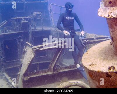 Ein Freitaucher sitzt auf einem Schiffswrack in Malta Stockfoto