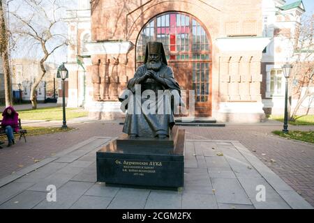 Denkmal des Heiligen Luka Voyno-Jasenetsky (2002) vor dem Eingang zur Pfarrei des Tempels des Heiligen Johannes des Vorläufers (1890) Stockfoto