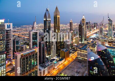 Wolkenkratzer überragen die städtische Wüste von Dubai, Vereinigte Arabische Emirate bei Sonnenaufgang Stockfoto