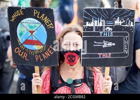 London, Großbritannien. - 10. September 2020: Ein Protestant hält Plakate während eines Protestes der Gruppe Extinction Rebellion auf dem Parliament Square hoch. Stockfoto