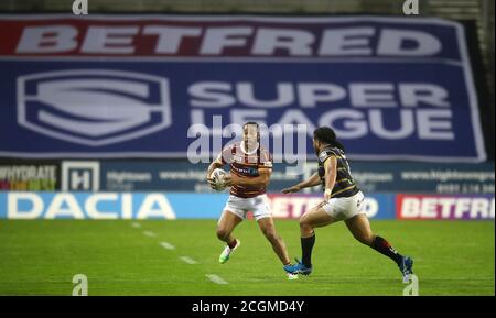 Huddersfield Giants' Leroy Cudjoe wird von Konrad Hurrell (rechts) von Leeds Rhinos während des Betfred Super League-Spiels im total Wicked Stadium, St. Helens, angegangen. Stockfoto