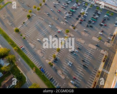 Riesige Parkplätze für Autos in der Nähe des Einkaufszentrums aus der Luft auf dem Parkplatz gibt es Autos, Parkplatz für halb leer. Stockfoto